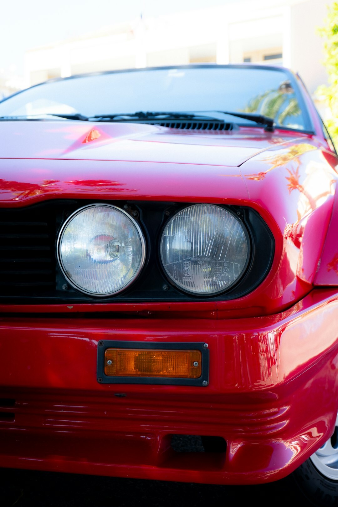 Close up of a vintage red Italian sports car front grille and headlight